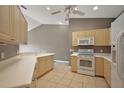 Bright kitchen featuring tile flooring, white countertops, and classic wooden cabinets and modern appliances at 5359 Compass Pt, Oxford, FL 34484