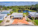 Aerial view showcasing home with a charming carport and scenic pond views at 710 Dolphin Dr, Tavares, FL 32778