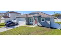 Attractive one-story home showing the driveway, red front door and manicured lawn at 717 Robin Ct, Kissimmee, FL 34759