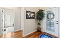 Inviting foyer with hardwood floors, a decorative world map and plant, and a white front door at 724 Barefoot Bay Loop, Groveland, FL 34736