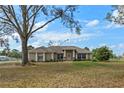Attractive single-story home featuring a well-maintained lawn, mature trees, and inviting curb appeal at 7729 Lake Andrea Cir, Mount Dora, FL 32757