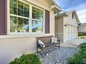 Close up of a wooden bench with pillows, landscaped yard with grass and decorative rocks at 9113 Sw 91St Court Rd, Ocala, FL 34481