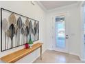 Light, airy foyer with tiled floors, decorative wall art, table, and door with glass at 9113 Sw 91St Court Rd, Ocala, FL 34481