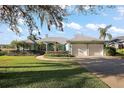 Charming curb appeal featuring a well-manicured lawn and a circular driveway leading to the two-car garage at 10610 Masters Dr, Clermont, FL 34711