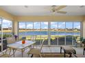 Relaxing sun room features panoramic lake views and comfortable seating with a ceiling fan at 1197 Eureka Mill Run, The Villages, FL 32162