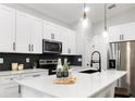 Modern kitchen featuring stainless steel appliances, a quartz countertop, a stylish backsplash, and sleek cabinetry at 12255 Sw 98Th St, Dunnellon, FL 34432
