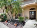 Landscaped front yard featuring mature palm trees and flowering plants at 1239 Russell Loop, The Villages, FL 32162