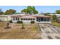 Inviting single-story home featuring a long driveway and a cozy screened-in porch at 1312 Apache Cir, Tavares, FL 32778