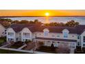 Stunning aerial view of the townhome complex with a beautiful sunset over the water in the background at 164 Nautica Mile Dr, Clermont, FL 34711