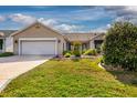 Beautiful home featuring a two-car garage, manicured lawn, and lovely landscaping for great curb appeal at 16721 Se 77Th Northridge Ct, The Villages, FL 32162