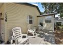 The side exterior of this cozy home features an outdoor seating area and convenient access at 1729 Lauren Ln, Lady Lake, FL 32159