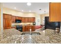 Modern kitchen with granite countertops, breakfast bar, wood cabinets, and stainless steel appliances at 1797 Pamplico Ct, The Villages, FL 32162