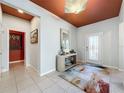 Bright foyer with stylish decor, a decorative ceiling, and tiled flooring leading to other rooms at 203 Silver Maple Rd, Groveland, FL 34736