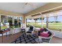 Comfortable sun room with wicker furniture and serene golf course views through large windows at 2068 Darlington Dr, The Villages, FL 32162