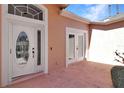 Front entrance featuring a leaded glass door and double french doors to the side at 20751 Queen Alexandra Dr, Leesburg, FL 34748