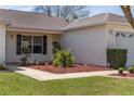 Close up of landscaped front yard with mulch, lighting, and fresh grass at 2712 Benavides Dr, The Villages, FL 32162