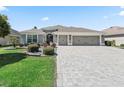 Lovely home with well manicured bushes, stone accents and a brick paved driveway at 3156 Vandenberg Ct, The Villages, FL 32163