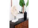Close-up of entry decor with modern cabinet, mirror, plants, and stylish sculptural pieces at 3180 Paradox Circle # 106, Kissimmee, FL 34746
