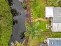 Aerial view showcasing a waterfront property with lush landscaping and a charming wooden walkway at 3211 Myakka River Rd, Tavares, FL 32778