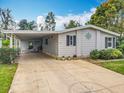 Inviting home with a covered carport and concrete driveway featuring a compass design at 3211 Myakka River Rd, Tavares, FL 32778