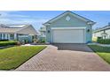 Charming single-story home features brick driveway, manicured lawn, and welcoming facade at 341 Silver Maple Rd, Groveland, FL 34736