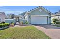 Charming single-story home features brick driveway, manicured lawn, and welcoming facade at 341 Silver Maple Rd, Groveland, FL 34736