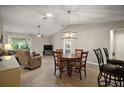 Open dining area featuring a vaulted ceiling, modern chandelier, and seamless flow to the living spaces at 3655 Idlewood Loop, The Villages, FL 32162