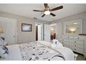 Cozy bedroom with a ceiling fan, dresser, and an open doorway to the rest of the home at 3655 Idlewood Loop, The Villages, FL 32162