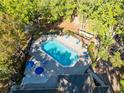 Aerial view of community pool with lounge chairs surrounded by mature trees at 5255 Images Cir # 207, Kissimmee, FL 34746