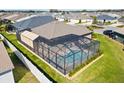 Aerial view of a screened-in pool and patio, surrounded by a well-maintained yard and privacy fence at 6088 Keckonen Dr, The Villages, FL 32163