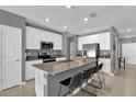 Modern kitchen featuring stainless steel appliances, an island with bar seating, and white cabinets at 6856 Perch Hammock Loop, Groveland, FL 34736