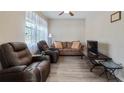 Cozy living room with hardwood floors, comfortable seating, and a large window with lots of sunlight at 906 Shady Canyon Way, Poinciana, FL 34759