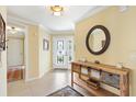 Inviting foyer with decorative mirror, elegant console table, and stylish rug, creating a warm and welcoming entrance at 1143 Barrineau Pl, The Villages, FL 32163