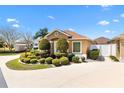 Beautiful single-story home boasts green shutters and meticulously landscaped grounds, enhancing its curb appeal at 1143 Barrineau Pl, The Villages, FL 32163