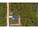 Overhead aerial view of a modern home situated on a spacious lot surrounded by dense trees, illustrating its seclusion at 12444 Sw 76Th Ln, Dunnellon, FL 34432