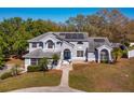 Beautiful two-story home with solar panels, a manicured lawn, and mature trees at 12815 Katherine Cir, Clermont, FL 34711