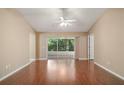 Inviting living room featuring hardwood floors, neutral walls, and sliding glass doors to a screened in lanai at 1419 Segovia Pl, The Villages, FL 32162