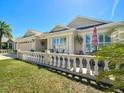 Inviting exterior showcasing the home's manicured lawn, stately columns, and charming front porch at 1430 Hillstream St, The Villages, FL 32163