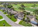 Aerial view of a well-maintained home, green lawns, and landscaping, with a golf course in the background at 1726 Augustine Dr, The Villages, FL 32159