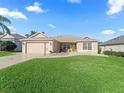 Inviting single-Gathering home with a manicured lawn, attached garage, and a charming walkway leading to the front door at 17660 Se 81St Timberwood Ter, The Villages, FL 32162