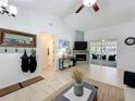 Neutral living room with vaulted ceilings, a ceiling fan, and an electric fireplace at 18319 Dells Cove Rd, Groveland, FL 34736