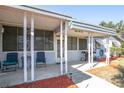 Inviting covered porch with seating, ideal for relaxing and enjoying the outdoors with a grill at 19050 Nfs-573, Altoona, FL 32702