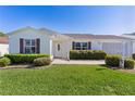 Well-maintained single-story home with green lawn and attractive landscaping at 2008 Cipriano Pl, The Villages, FL 32159