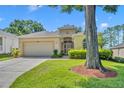 Charming single-story home featuring a well-manicured lawn and attached two-car garage at 2205 Stonebridge Way, Clermont, FL 34711