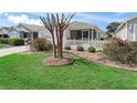 Landscaped front yard with a decorative tree and a neatly maintained lawn enhances the curb appeal of this home at 3382 Carrabelle Ct, The Villages, FL 32163