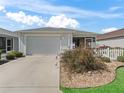 Beautiful home featuring a two-car garage, landscaped front yard, and a charming white picket fence at 3382 Carrabelle Ct, The Villages, FL 32163