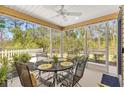 Enclosed patio features a ceiling fan and metal table with four chairs at 3441 Possehl Pl, The Villages, FL 32163