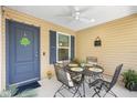 Covered front porch with seating area including a metal table and chairs at 3441 Possehl Pl, The Villages, FL 32163