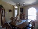 Formal dining room showcasing natural light, a chandelier, and traditional furnishings at 36709 Sandy Ln, Grand Island, FL 32735