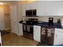 Well-lit kitchen featuring white cabinetry, stainless steel appliances, and contrasting countertops at 36709 Sandy Ln, Grand Island, FL 32735